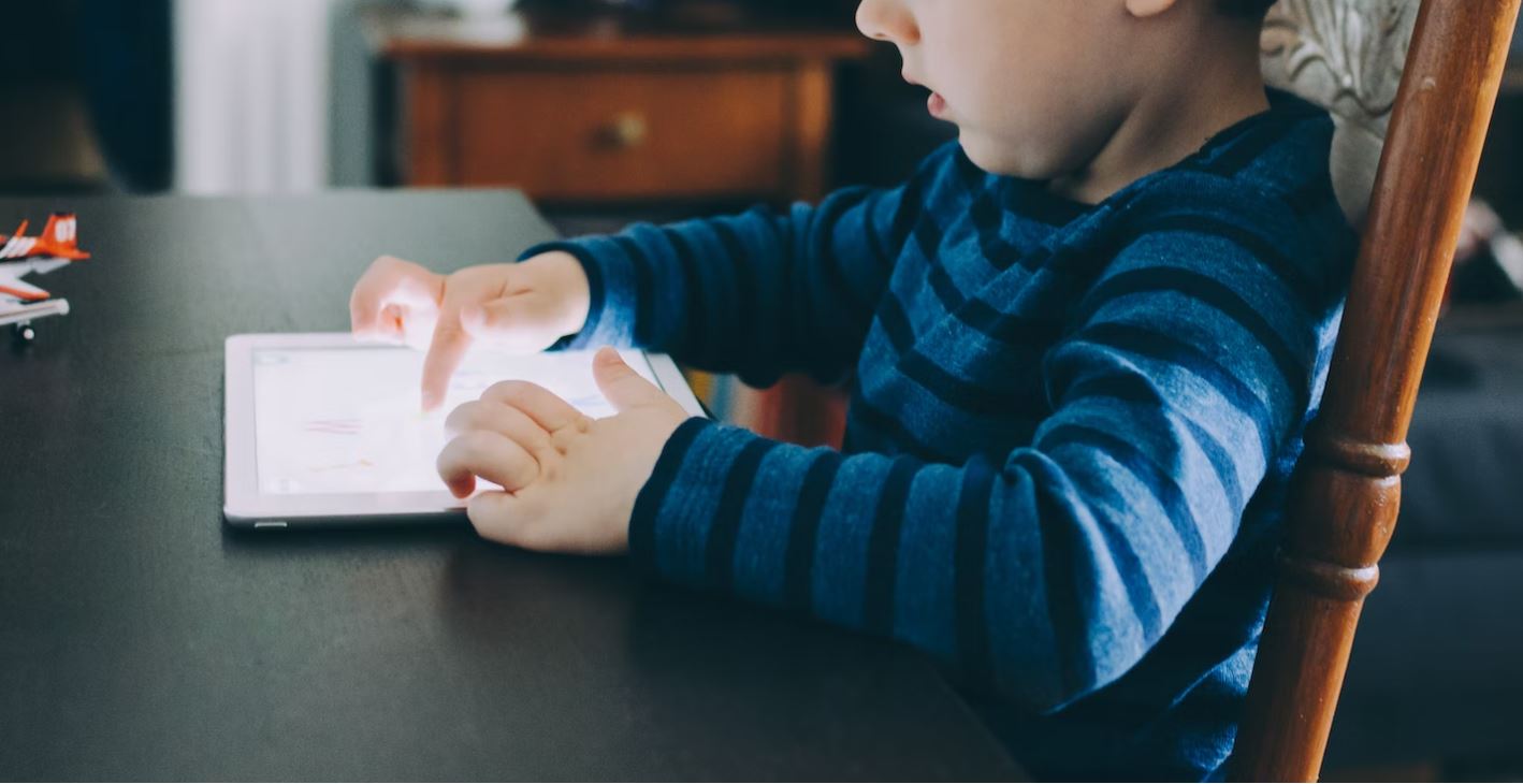 enfant qui joue avec un écran tactile à nettoyer